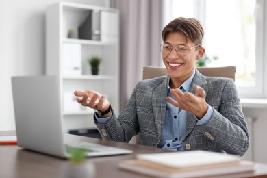 Man using video chat during webinar at wooden table in office