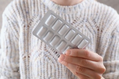 Woman holding blister with chewing gums, closeup