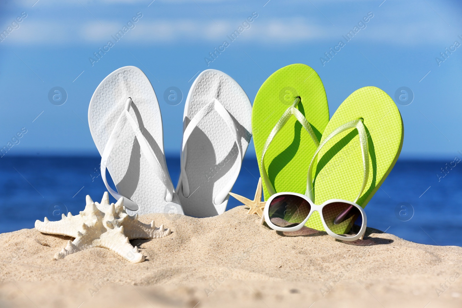 Photo of Composition with beach accessories on sand near sea in summer