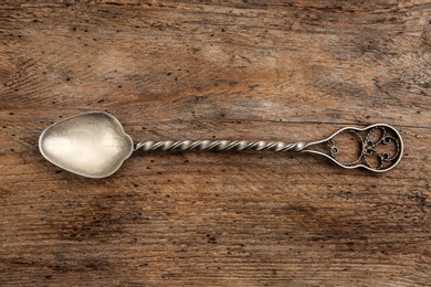 Photo of Clean vintage tea spoon on wooden background, top view