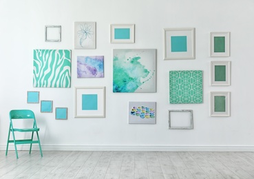 Many abstract mint paintings on light wall