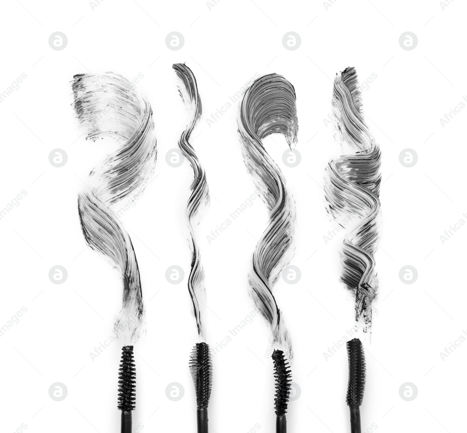 Photo of Different brushes and mascara strokes on white background