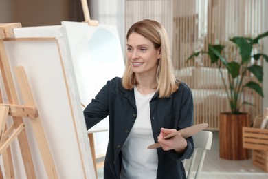 Photo of Beautiful woman painting in studio. Creative hobby