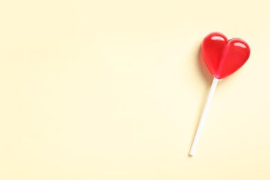 Photo of Sweet heart shaped lollipop on beige background, top view with space for text. Valentine's day celebration