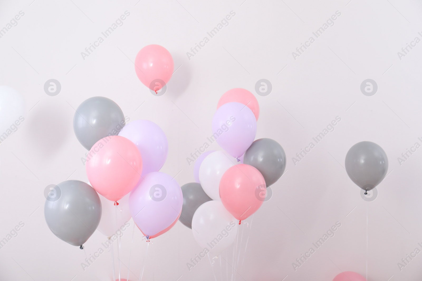 Photo of Bright balloons near color wall. Festive decoration