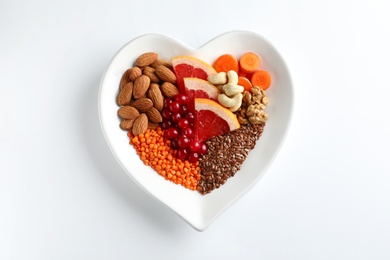 Plate with products for heart-healthy diet on white background, top view