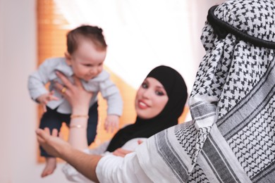 Photo of Happy Muslim family with little son at home