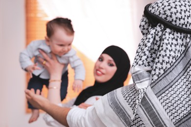 Happy Muslim family with little son at home