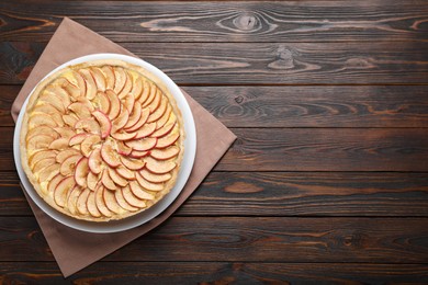 Photo of Freshly baked delicious apple pie on wooden table, top view. Space for text