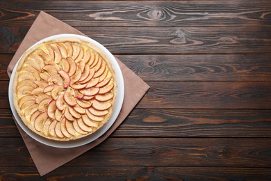 Freshly baked delicious apple pie on wooden table, top view. Space for text