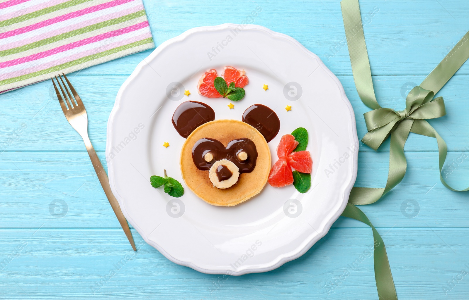 Photo of Funny pancake for kids breakfast on wooden table, top view