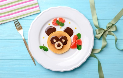 Funny pancake for kids breakfast on wooden table, top view