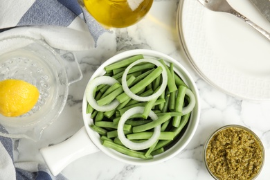 Flat lay composition with raw green beans on white marble table