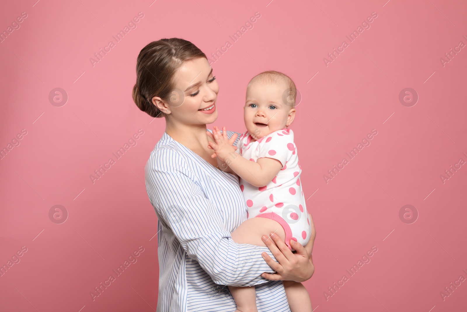 Photo of Portrait of happy mother with her baby on color background