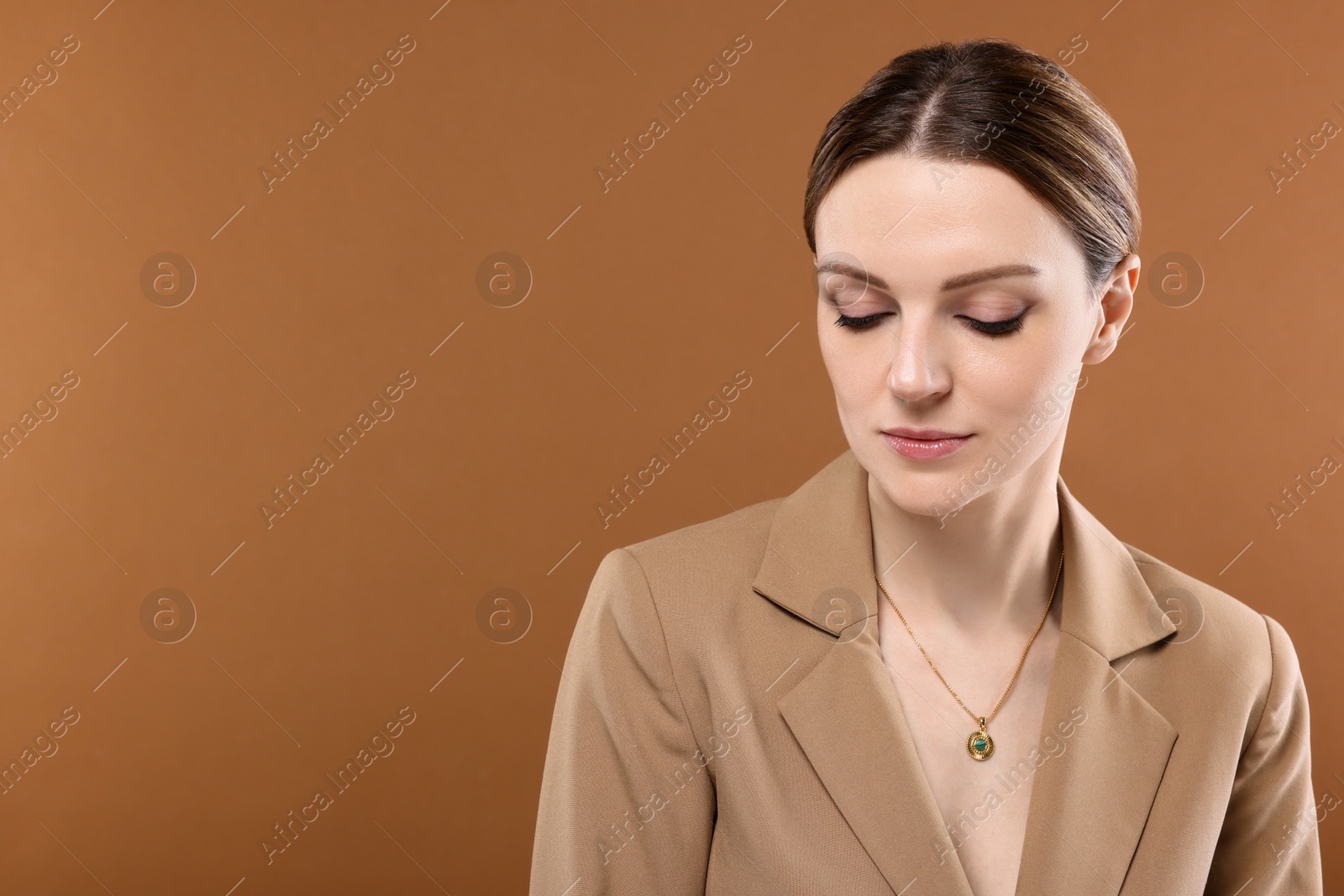 Photo of Beautiful woman with elegant necklace on brown background. Space for text