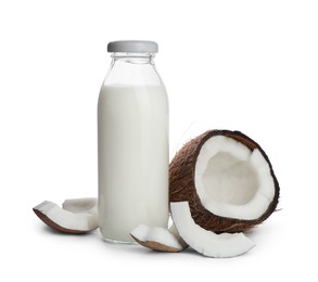 Bottle of coconut milk and nut on white background