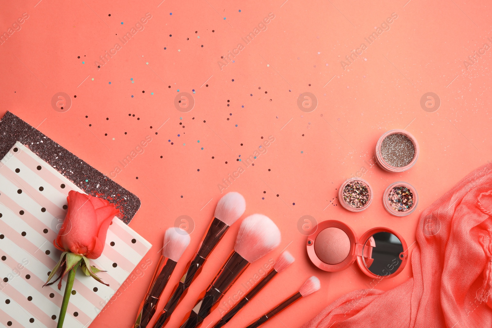 Photo of Flat lay composition with beauty accessories, notebooks and rose on coral background. Space for text