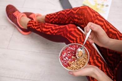 Young woman in fitness clothes having healthy breakfast at home, closeup