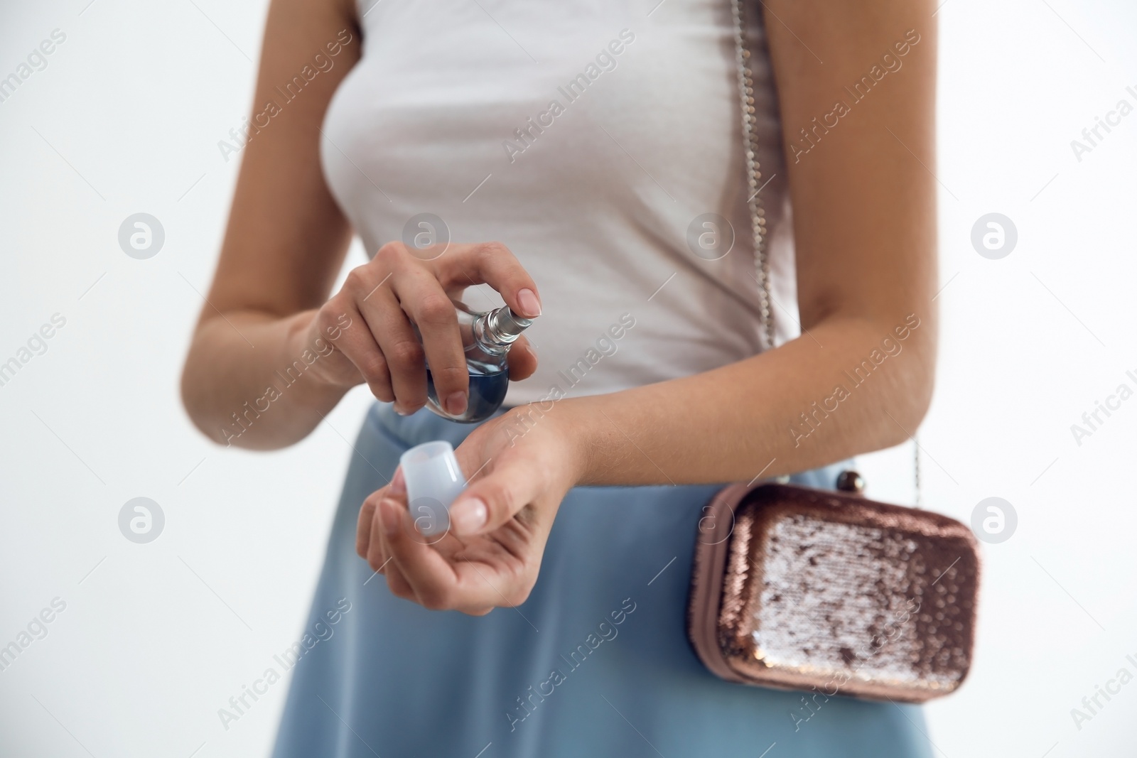 Photo of Young woman using perfume indoors, closeup