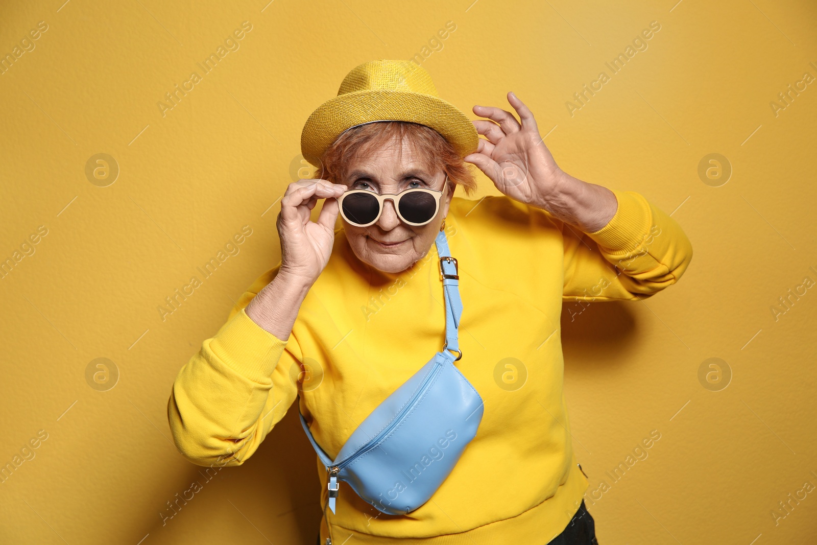 Photo of Portrait of elderly woman in hipster outfit on color background