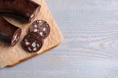 Photo of Tasty blood sausage on grey wooden table, above view. Space for text