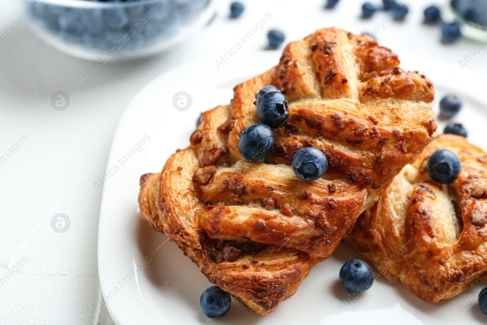 Photo of Fresh delicious puff pastry with sweet berries served on light table, closeup