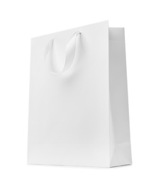 Photo of Paper shopping bag with ribbon handles on white background. Mockup for design