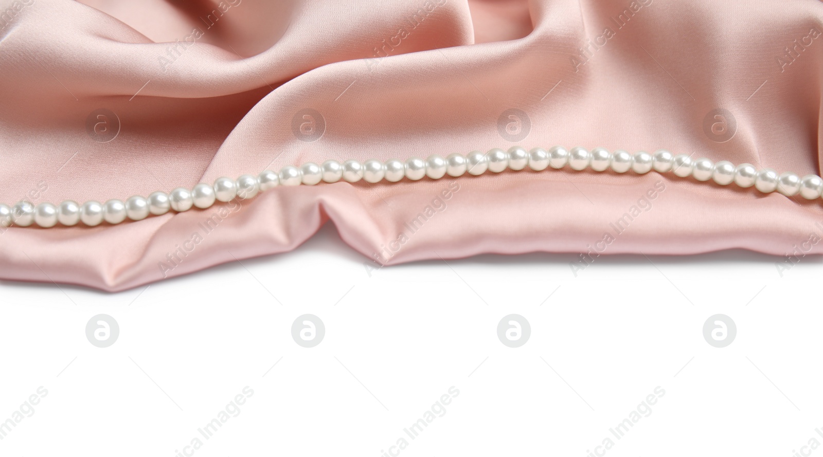 Photo of Beautiful pearls and pink silk on white background