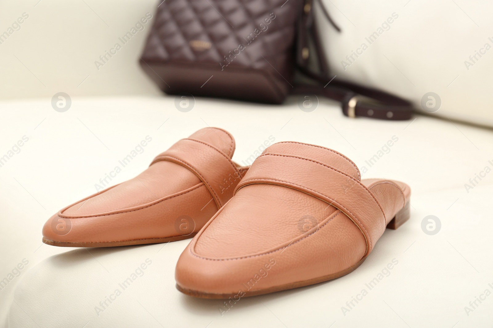 Photo of Pair of female shoes on sofa, closeup