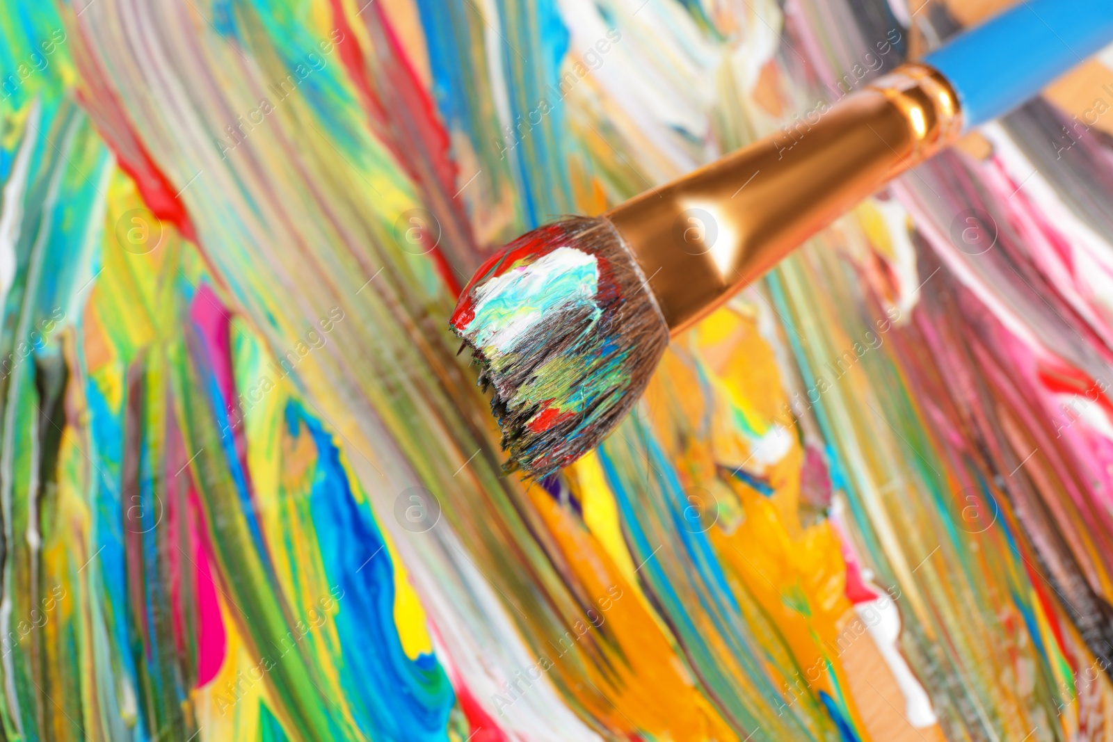 Photo of Abstract colorful acrylic paint and brush, closeup view