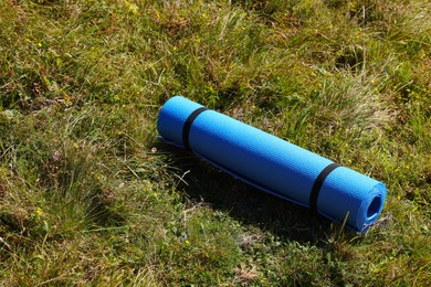 Rolled blue soft sleeping pad on grass