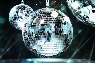 Image of Shiny disco balls on dark background with blurred lights, bokeh effect