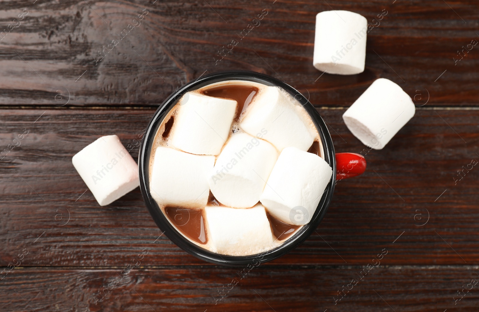 Photo of Tasty hot chocolate with marshmallows on wooden table, top view