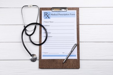 Photo of Medical prescription form with empty fields, stethoscope and pen on white wooden table, flat lay