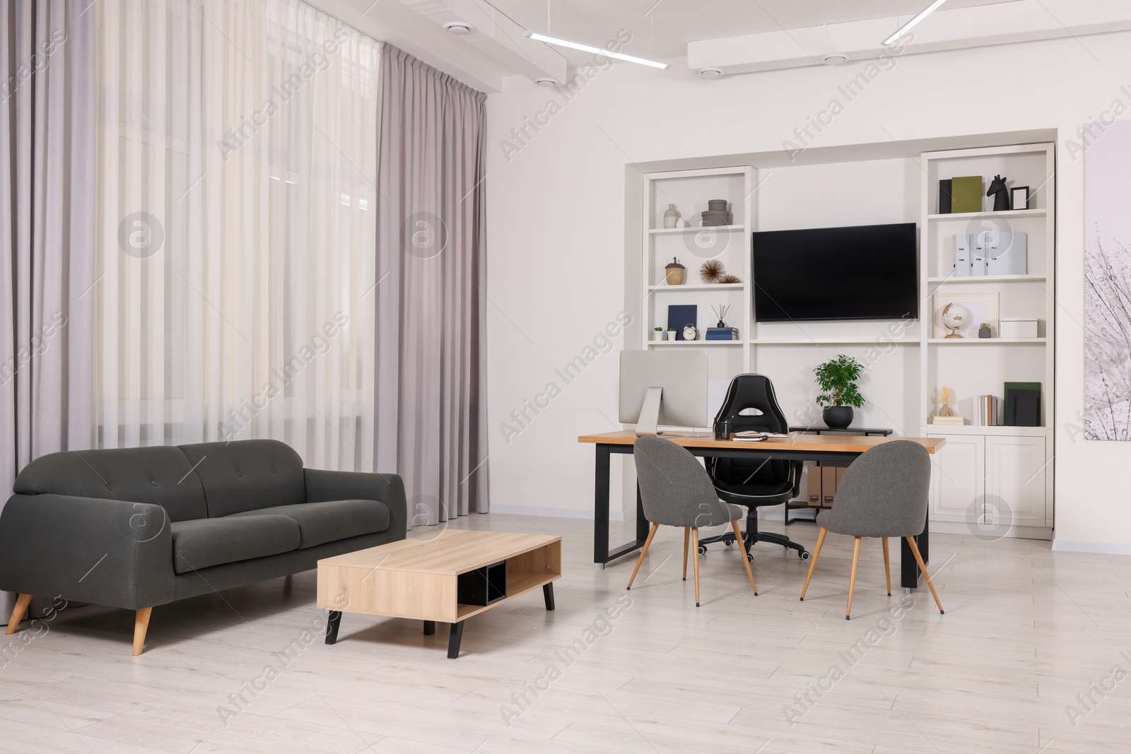 Photo of Stylish director's workplace with comfortable furniture and tv zone in room. Interior design