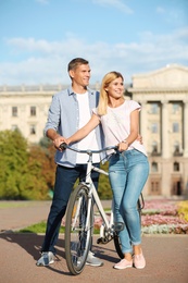 Photo of Happy couple with bicycle outdoors on sunny day