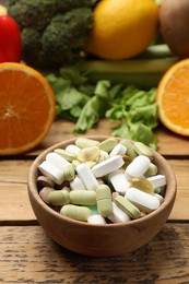 Photo of Dietary supplements. Different pills in bowl and food products on wooden table