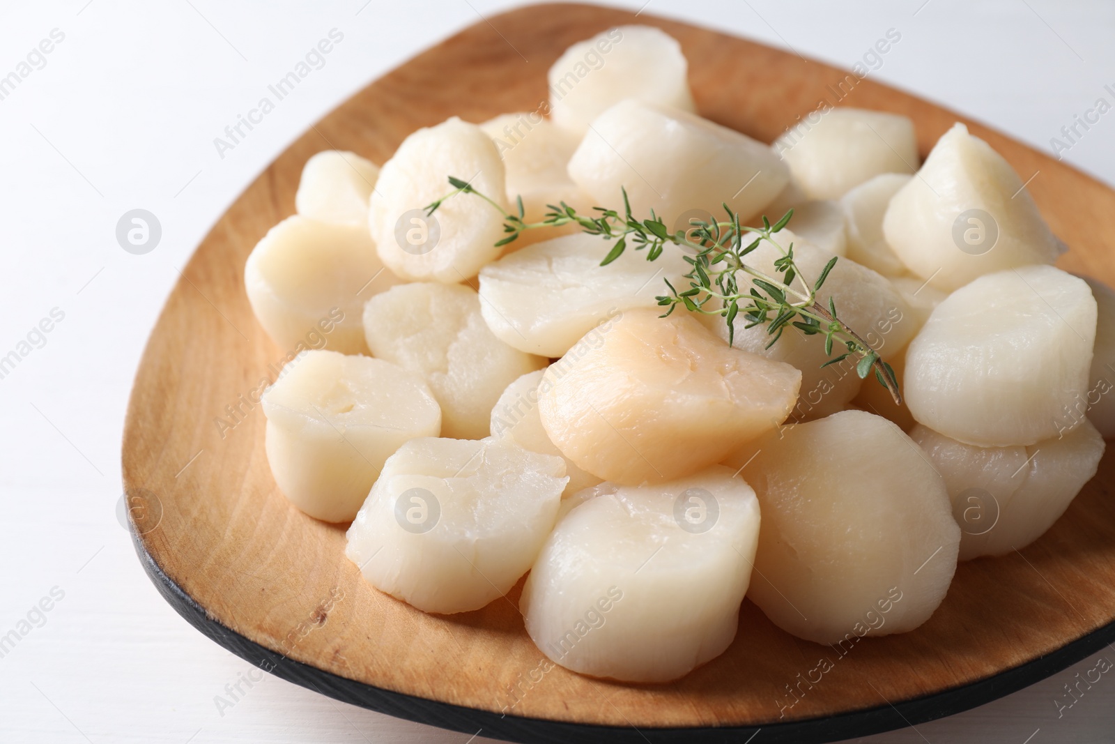 Photo of Fresh raw scallops and thyme on white table, closeup