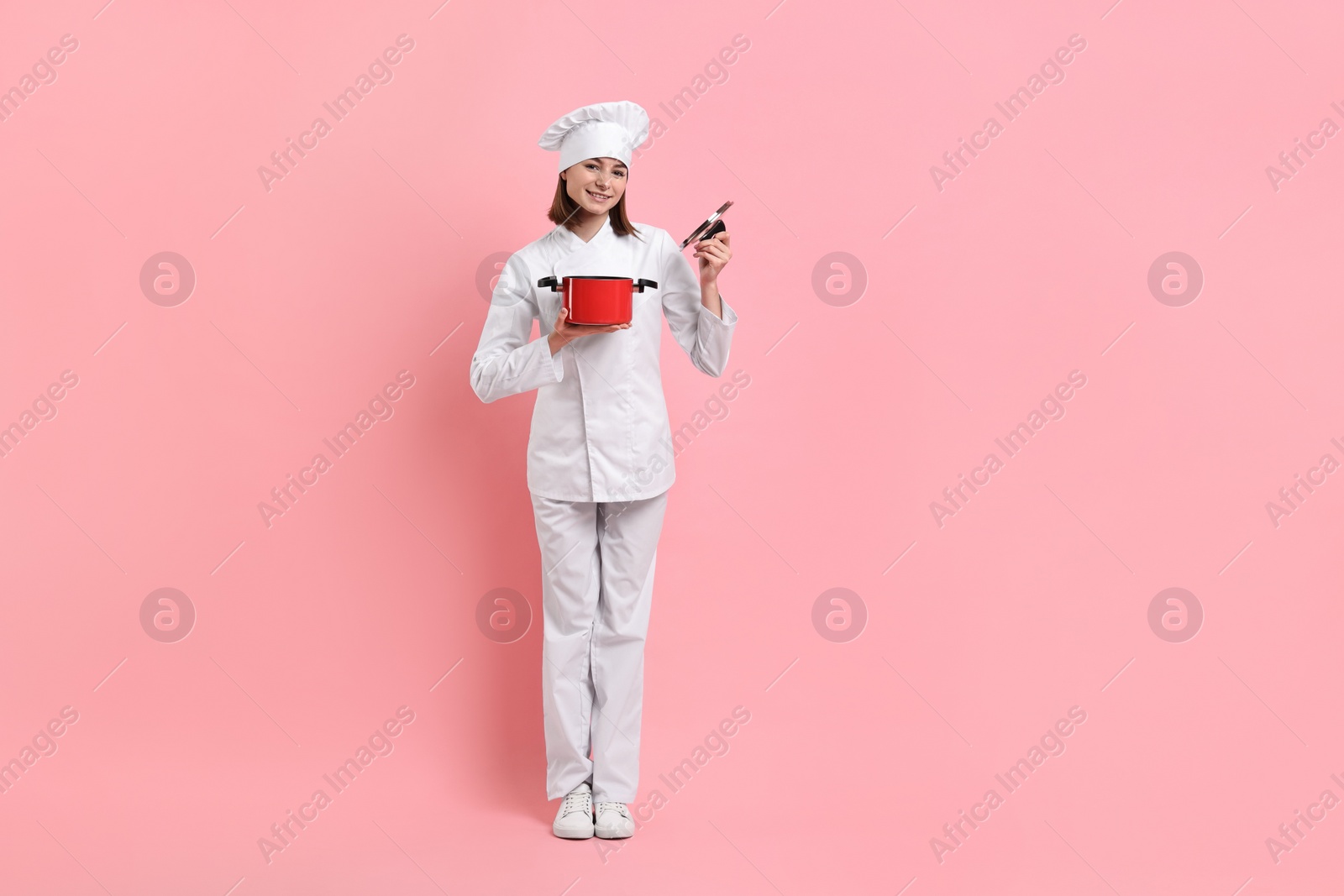 Photo of Professional chef with cooking pot on pink background