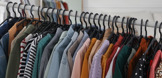 Image of Rack with stylish clothes indoors, banner design. Fast fashion