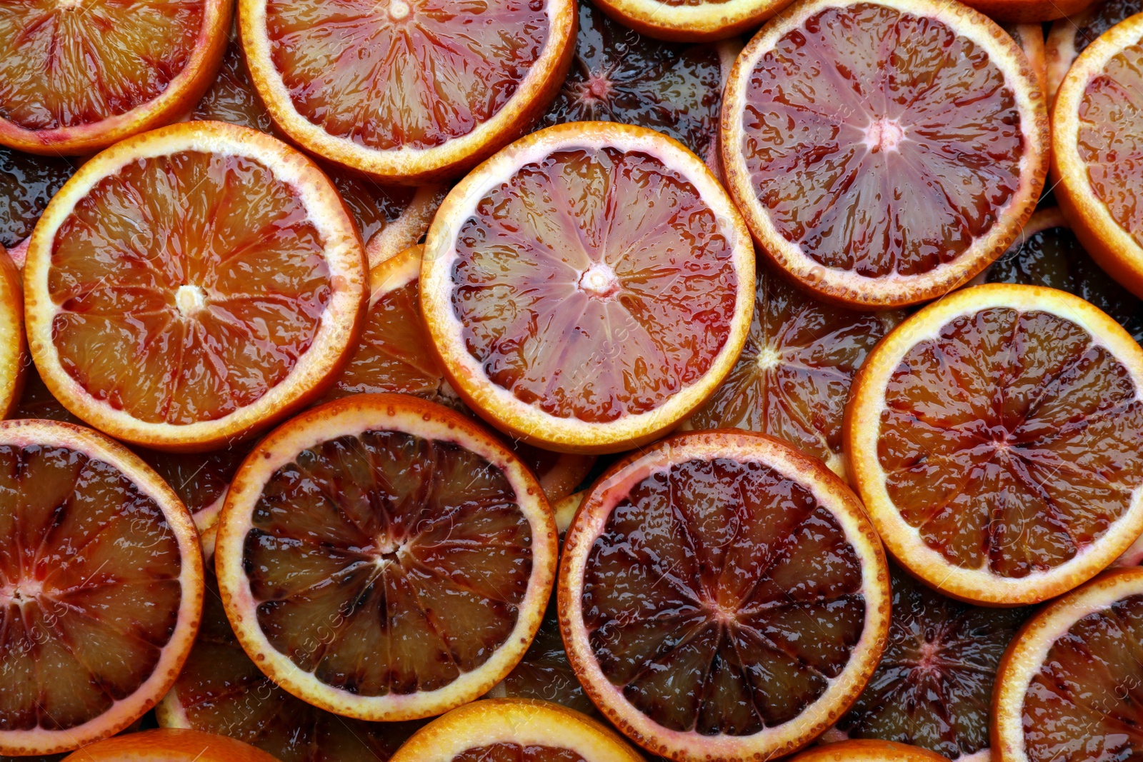 Photo of Slices of ripe sicilian oranges as background, top view