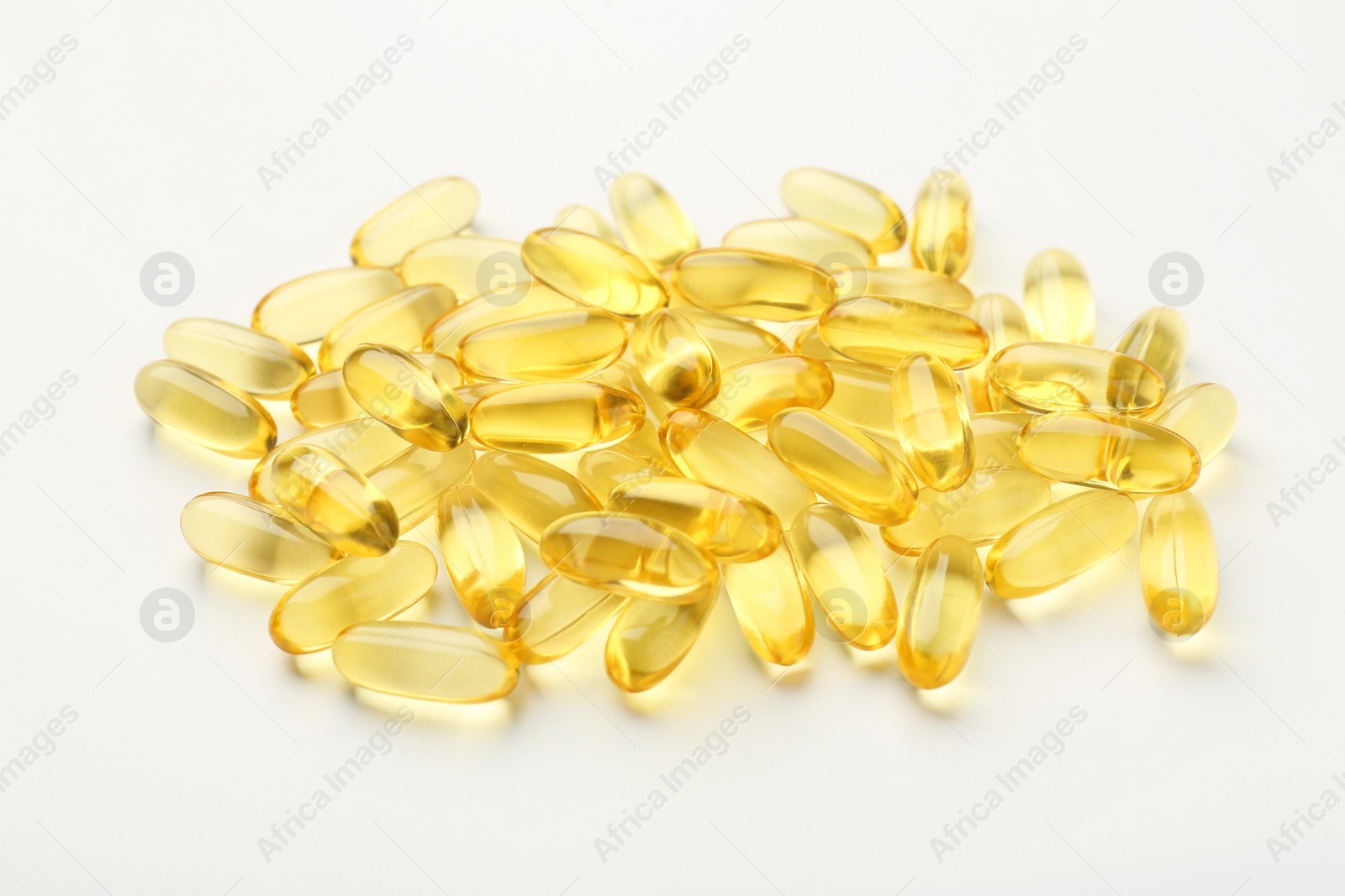 Photo of Many yellow vitamin capsules on white background