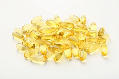 Photo of Many yellow vitamin capsules on white background