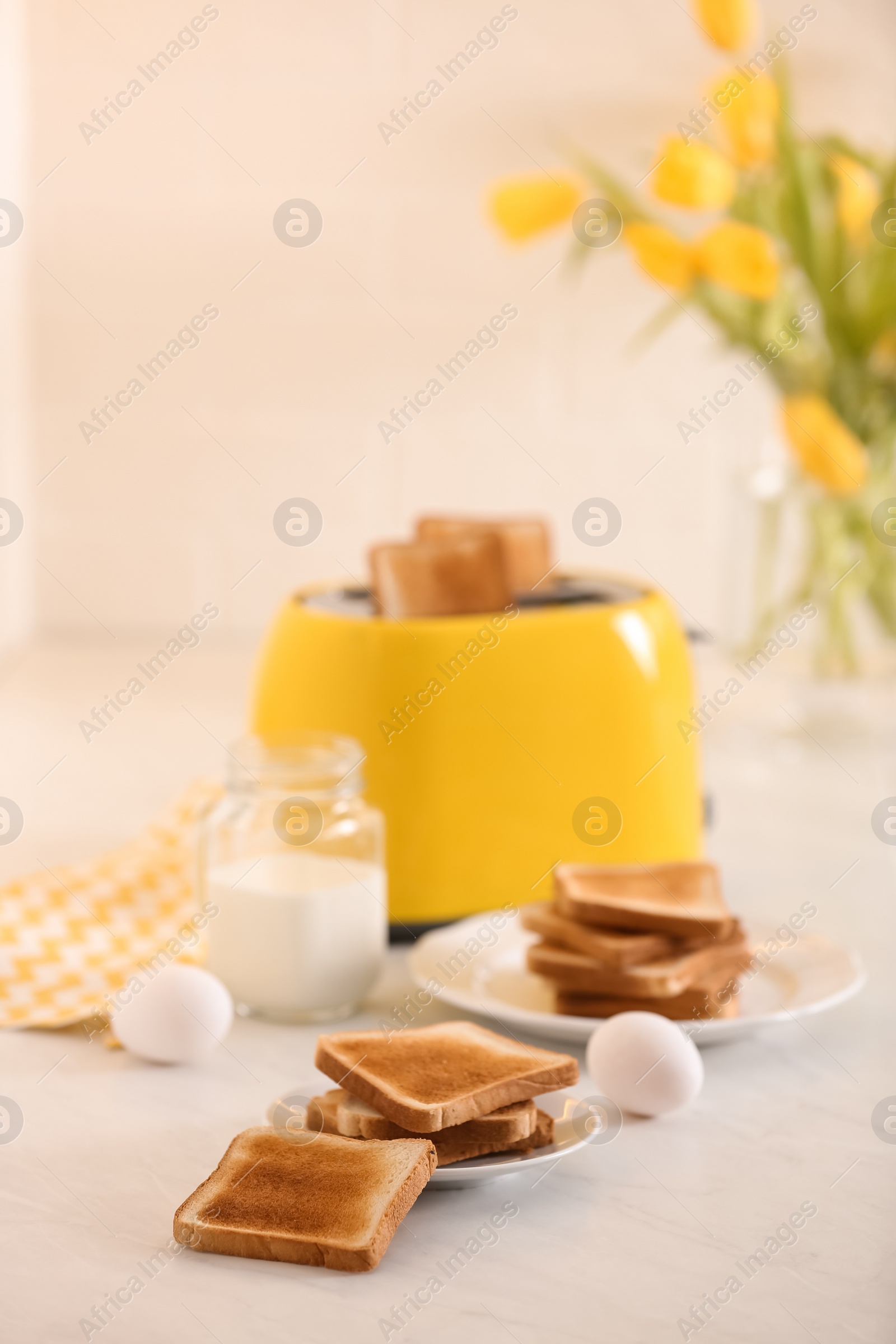 Photo of Modern toaster and delicious breakfast on table in kitchen