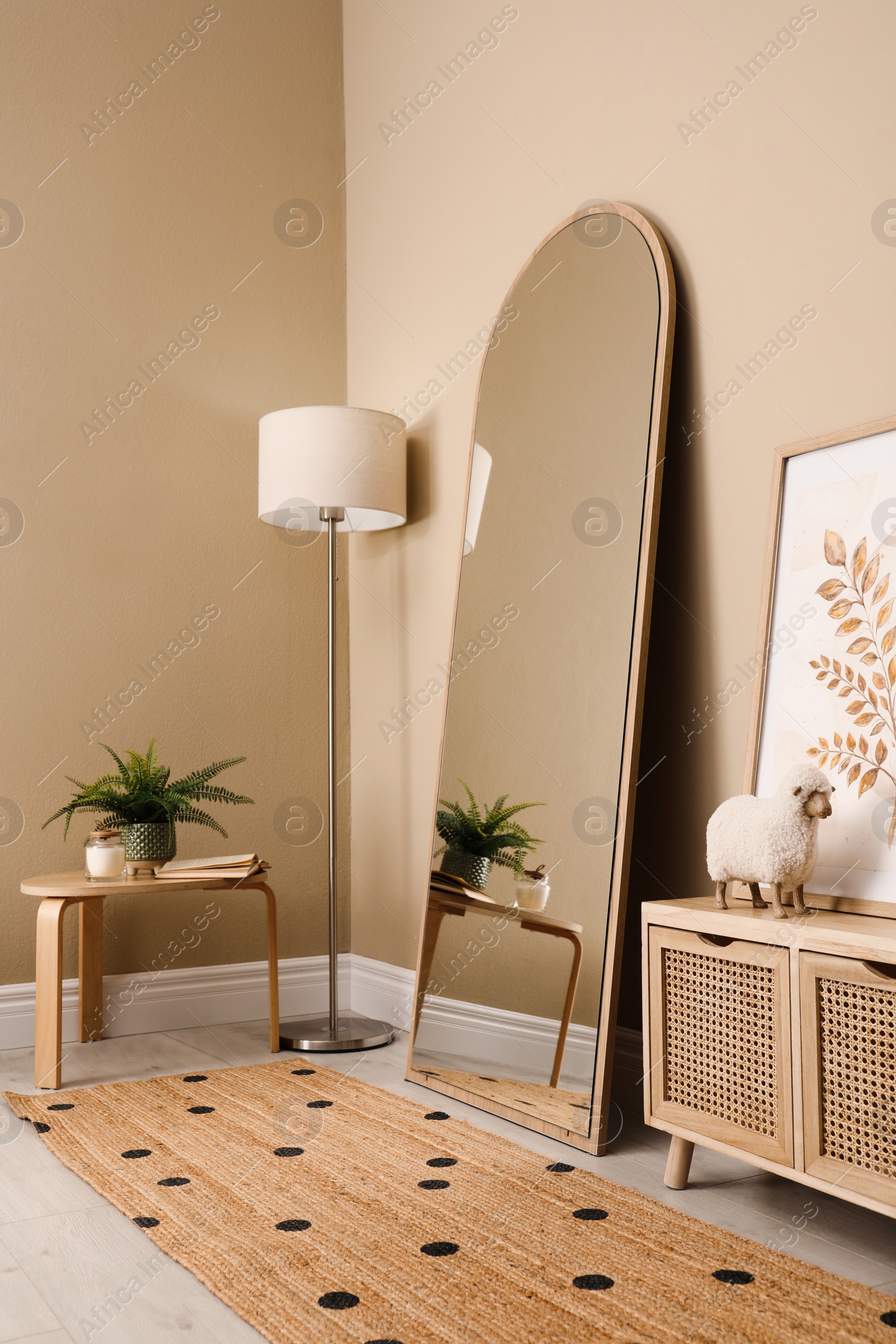 Photo of Beautiful mirror and console table near beige indoors. Interior design