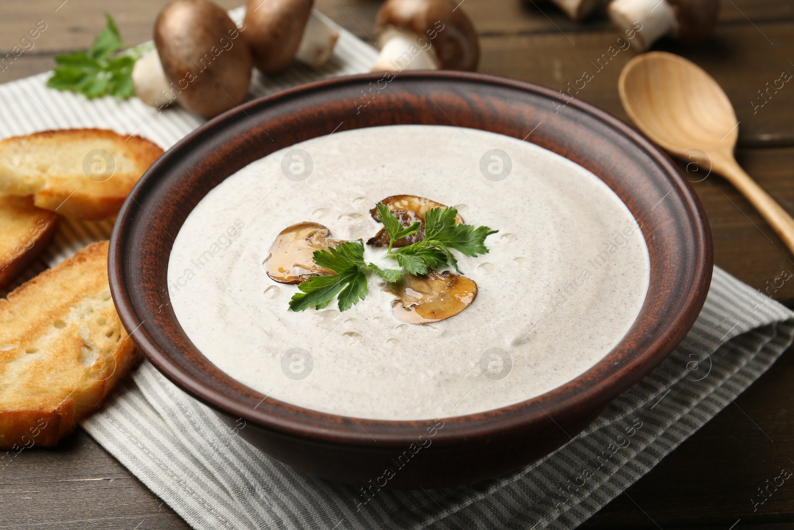 Photo of Fresh homemade mushroom soup served on wooden table