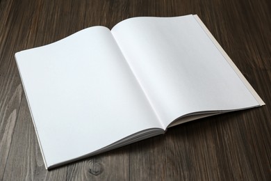 Open blank paper brochure on wooden table. Mockup for design