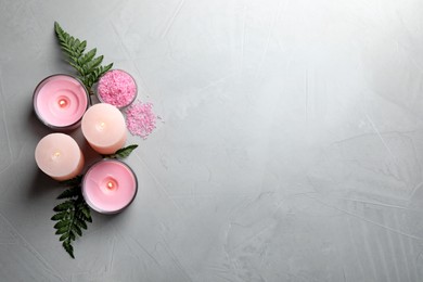 Photo of Candles, fern leaves and sea salt on light grey stone table, flat lay. Space for text