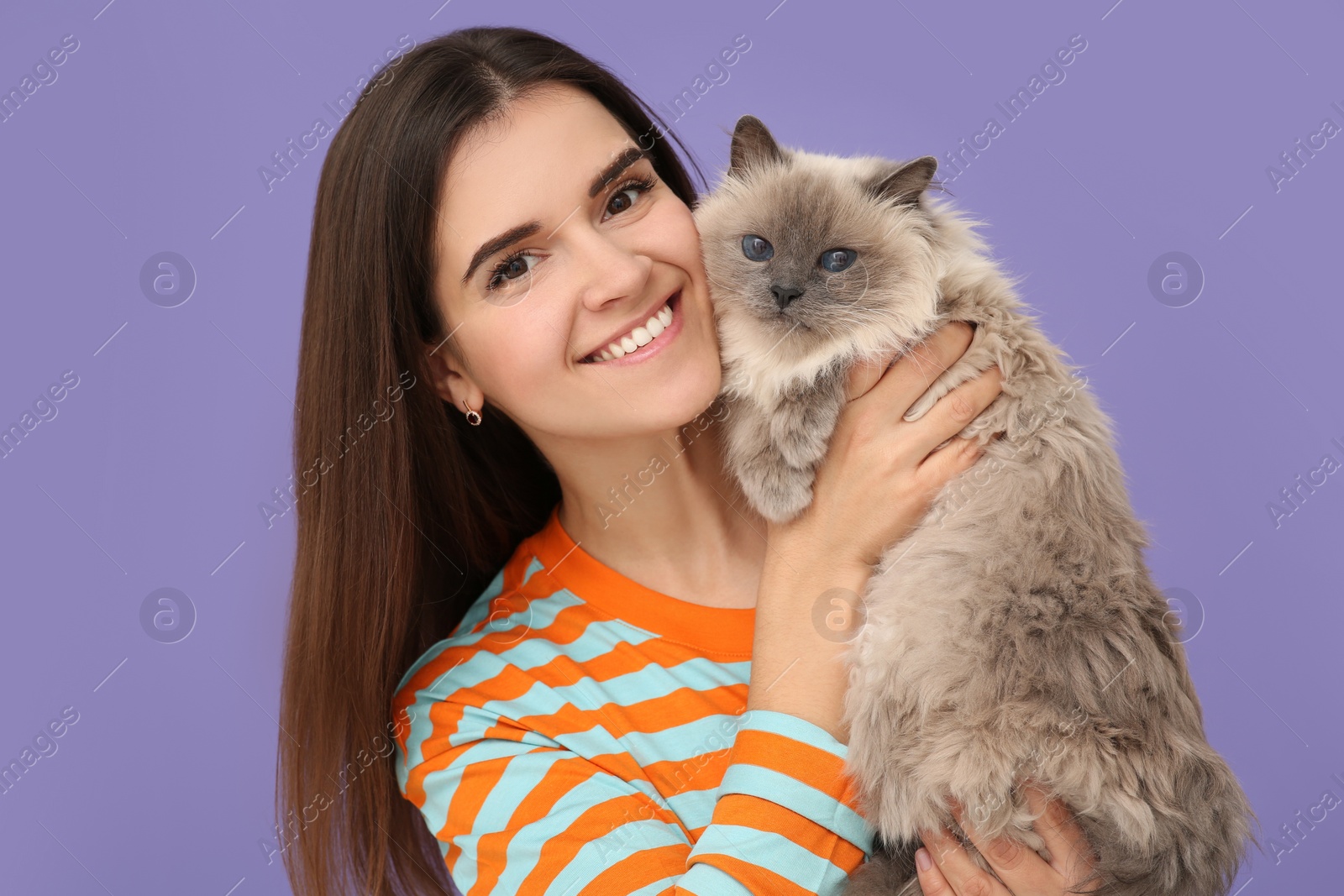 Photo of Happy woman with her cute cat on violet background