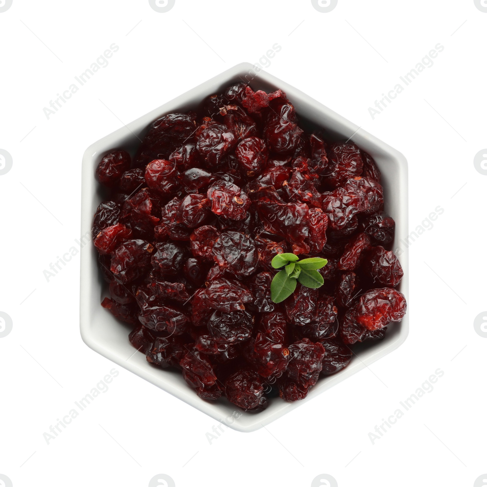 Photo of Tasty dried cranberries and leaves in bowl isolated on white, top view